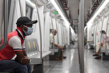 Los viajeros se sientan en un vagón de un tren de la Línea Amarilla después de que Delhi Metro Rail Corporation (DMRC) reanudara los servicios tras su cierre debido a la pandemia de coronavirus en Nueva Delhi el 7 de septiembre de 2020