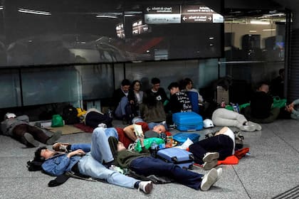 Los viajeros yacen en el suelo mientras se preparan para pasar la noche en la estación de tren de Atocha, tras un corte de luz masivo que afectó a toda la península Ibérica y al sur de Francia