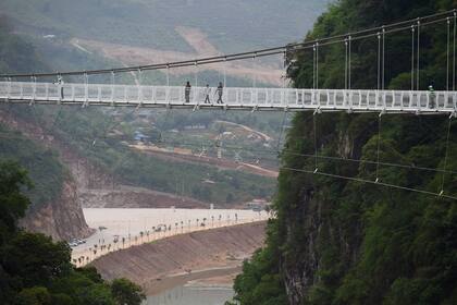 Los visitantes caminan por el puente de cristal Bach Long en Vietnam, el 29 de abril de 2022