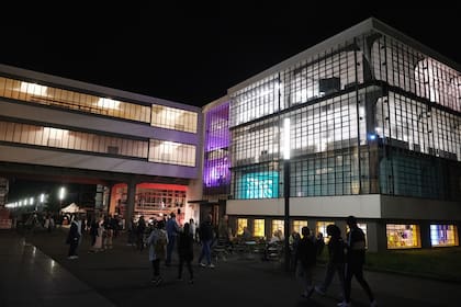 Los visitantes caminan por la Bauhaus, coloridamente iluminada