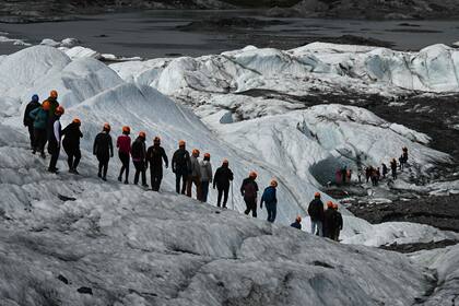 Los visitantes caminan sobre el hielo durante una visita guiada al glaciar Matanuska, un glaciar de 43,5 km de largo que alimenta con agua al río Matanuska, a 161 km al noreste de Anchorage, cerca de Palmer, Alaska