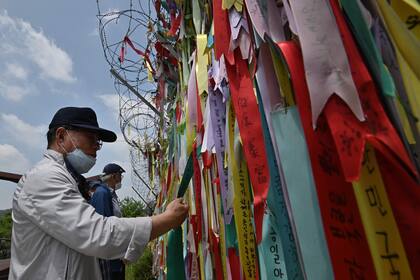Los visitantes miran cintas que desean la paz y la reunificación de la península de Corea
