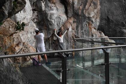 Los visitantes posan para fotos en la sección de la pasarela del puente de vidrio Bach Long en el distrito de Moc Chau en la provincia de Son La de Vietnam el 29 de abril de 2022