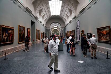 Los visitantes que usan mascarilla protectora miran las pinturas en el museo del Prado mientras se reabre al público bajo estrictas medidas de distancia social, en medio del brote de la enfermedad del coronavirus (COVID-19), en Madrid, España