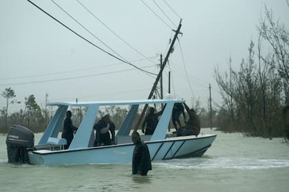 Los voluntarios parten en un bote a motor para rescatar a las personas atrapadas por las crecientes aguas del huracán Dorian, en una carretera inundada cerca del puente Causarina en Freeport, Gran Bahama
