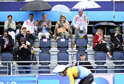 Los voluntarios tuvieron una ardua tarea para intentar proteger a los invitados VIP de la lluvia. Felipe y Marilde de Bélgica alentaron a equipo de ciclismo