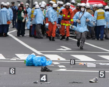 Los zapatos de las víctimas en una calle mientras los rescatistas del Departamento de Policía Metropolitana de Tokio trabajan en el distrito de Akihabara de Tokio después la masacre, en 2008