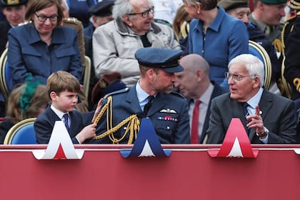 Louis tironea del uniforme de su padre para llamarle la atención mientras conversa.