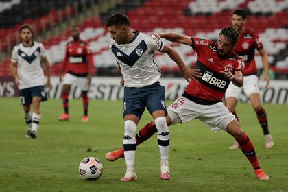 Lucas Janson ante Mauricio Isla; no se sacaron ventajas entre Vélez y Flamengo, en Río de Janeiro, por la Copa Libertadores