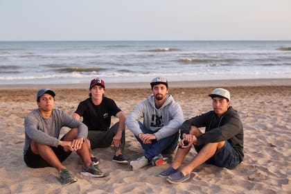 Lucas, José, Pablo y Fernando, los hijos de Ramón Román, se sientan en la playa poco después de ser informados de que Prefectura dejará de buscar a su padre con vida