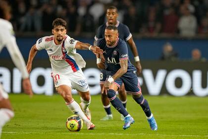 Lucas Paqueta, del Lyon, a la izquierda, desafía a Neymar del PSG durante el partido de fútbol de la Liga Uno de Francia entre el Paris Saint-Germain y el Lyon en el Parc des Princes en París el domingo 19 de septiembre de 2021.
