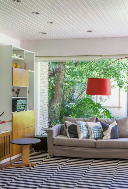 Luce súper actual, pero el techo revestido con listones de madera es original de la casa. Almohadones (Plaintextiles).