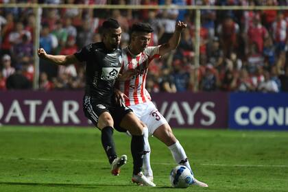 Lucha por la pelota entre Daniel Giraldo y Lucas Esquivel