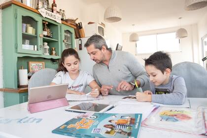 Luciano revisa carpetas y se ocupa de temas escolares con sus hijos, con clases virtuales, por el confinamiento