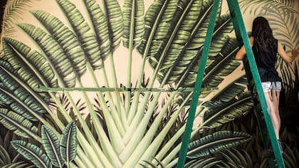 Lucila Domínguez pintando uno de sus murales selváticos