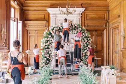 Lucila y el equipo de floristas trabajando en el arco de ceremonia de la boda.