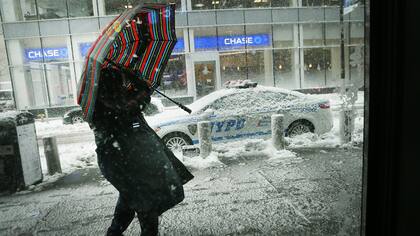 Una mujer camina en la nieve y el viento en Manhattan