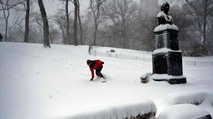 Un hombre hace snowboard en el Central Park durante una tormenta de invierno en Nueva York