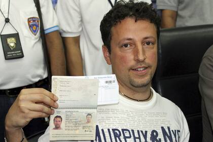 Luigi Maraldi muestra su Nuevo pasaporte para confirmar que él no estaba en el avión