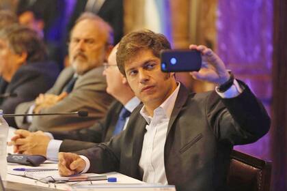 El exministro de Economía Axel Kicillof se saca una selfie durante la exposición de Caputo