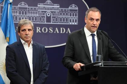 Luis Caputo y Manuel Adorni en la sala de conferencias de prensa de la Casa Rosada