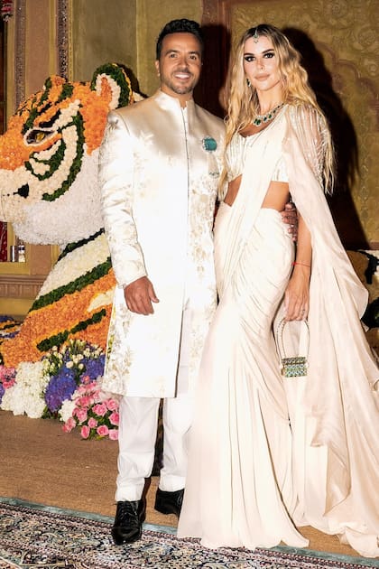 Luis Fonsi, encargado del show
en vivo, posa con su mujer, Águeda López (con un sari dorado de Anamika Khanna) delante de una de las 60
esculturas de animales con flores autóctonas de la India. Para cada una de las figuras se necesitaron más de
100.000 flores.