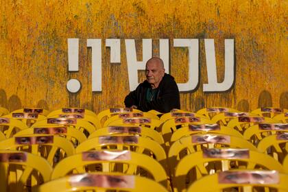 Luis Har, rescatado de su cautiverio impuesto por Hamás en una incursión israelí el año pasado, posa para una foto, rodeado de sillas vacías con fotografías de los ojos de otros rehenes, en Tel Aviv, Israel, el lunes 6 de enero de 2025.