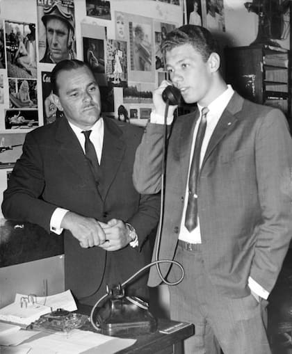 Luis Nicolao habla por teléfono. A su izquierda uno de sus entrenadores, Alberto Carranza, el que le advertía a Luis que no reunía las condiciones necesarias.