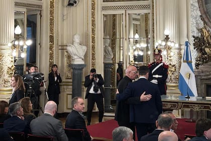 Luis Petri saluda al obispo castrense bajo la mirada de Lamelas