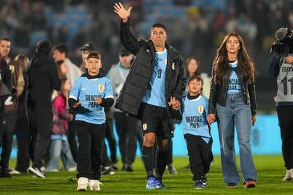 Luis Suárez, de la selección de Uruguay, agradece al público, acompañado por sus hijos, tras el partido que marcó su retiro de partidos internacionales, el viernes 6 de septiembre de 2024, ante Paraguay, en las eliminatorias mundialistas