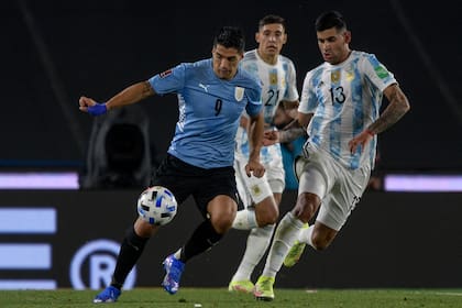 Luis Suarez lucha en el partido ante la Argentina ante Cristian Romero; los malos resultados pusieron en duda la continuidad de Tabárez, pero el DT fue ratificado