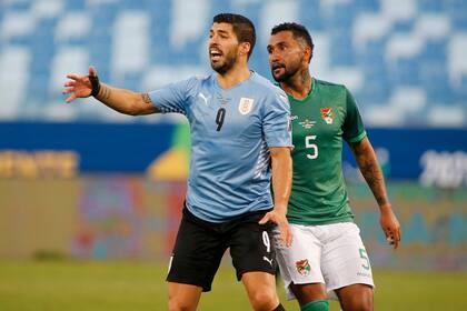 Luis Suarez protesta ante la marca de Adrian Jusino, en el primer tiempo del partido entre Uruguay y Bolivia.
