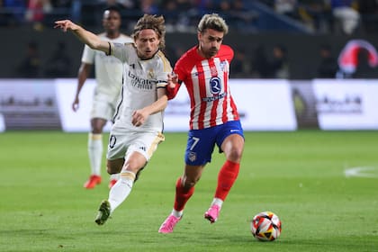 Luka Modric y Antoine Griezmann, figuras de Real Madrid y Atlético de Madrid, que este domingo ofrecerán un nuevo capítulo de su clásico, por la liga de España.