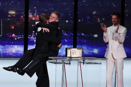 Lukas Dhont aplaude el festejo de Valentin Campagne y Emmanuel Macchia, protagonistas de su película Coward, elegidos como los mejores actores de Cannes 2026