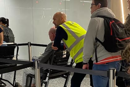 Luke Williams asiste a un pasajero con movilidad reducida en un aeropuerto
