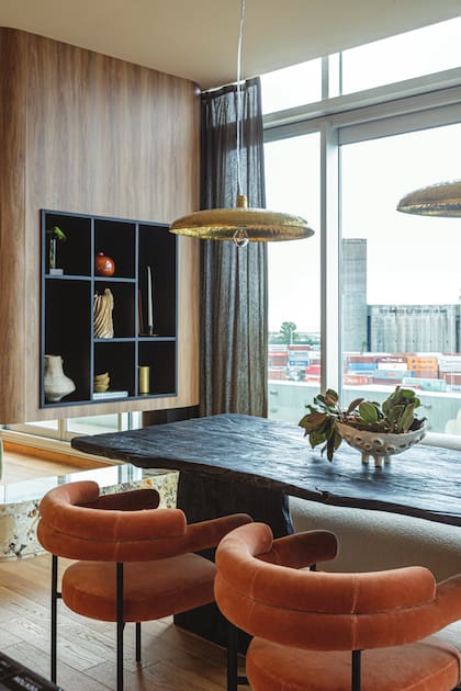 Luminarias de Casa Sixta sobre la mesa de madera quemada trabajada artesanalmente con hacha y sillas tapizadas en terciopelo (todo de Rob Ortiz).