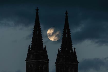 La luna llena sale detrás de la Basílica de San Pedro y San Pablo, parte del Castillo de Vysehrad en Praga.