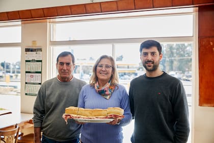Mabel Di Santis y Daniel Rivera atienden el bar El Cruce, en Balcarce, famoso por su sandwich de jamón crudo y queso, el Titán de Balcarce del tamaño de un antebrazo. Su hijo Ignacio es la cuarta generación que atiende el lugar conocido por viajeros que también eligen las opciones de matambre y jamón cocido.