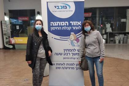 Mabel Sapollink Krawcyk, en el centro de vacunación con una amiga: el cartel indica que es una zona de espera luego de haber sido vacunado