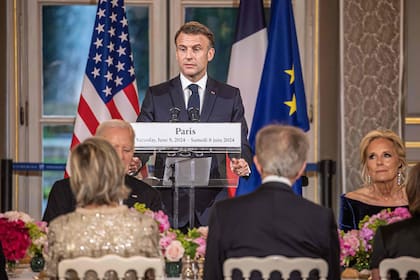 Macron habla en la cena del Palacio del Elíseo junto a Biden (Photo by Christophe PETIT TESSON / POOL / AFP)