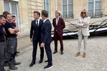 Macron saluda a Reinoso y a los obreros que lo ayudaron con la enorme estructura de hierro en la inauguración de su obra en el Elíseo
