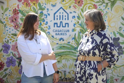 Madre e hija conversan en la terraza de Casaclub Baires, junto a un mural que los socios pintaron.