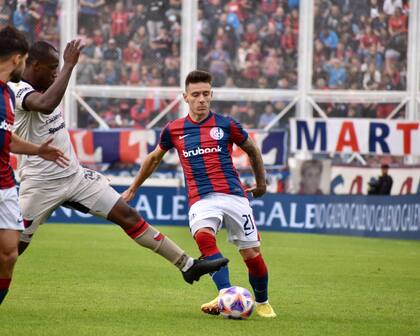 Malcom Braida, carrilero por la izquierda de San Lorenzo, es marcado por Baldomero Perlaza, mediocampista de Colón