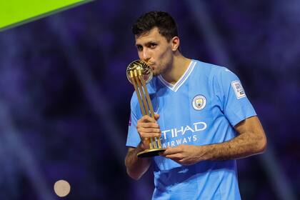 Manchester City's Spanish midfielder #16 Rodrigo Hernandez kisses his golden ball trophy during presentation at the end of the FIFA Club World Cup 2023 football final match against Brazil's Fluminense at King Abdullah Sports City Stadium in Jeddah on December 22, 2023. (Photo by Giuseppe CACACE / AFP)