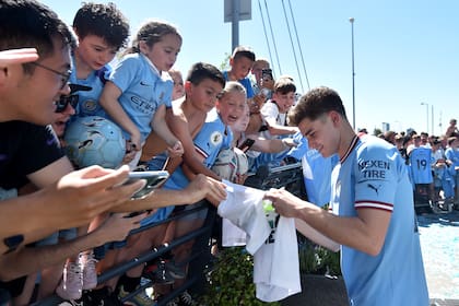 MANCHESTER, INGLATERRA - 10 DE JULIO: Julian Alvarez de Manchester City firma camisetas de fanáticos durante el evento de presentación de firmas de verano de Manchester City en el Etihad Stadium el 10 de julio de 2022 en Manchester, Inglaterra. (Foto de Manchester City FC/Manchester City FC a través de Getty Images)