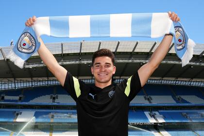 MANCHESTER, INGLATERRA - 10 DE JULIO: Julian Alvarez de Manchester City posa con una bufanda de Manchester City dentro del estadio durante el evento de presentación de firma de verano de Manchester City en el Etihad Stadium el 10 de julio de 2022 en Manchester, Inglaterra. (Foto de Matt McNulty - Manchester City/Manchester City FC a través de Getty Images)
