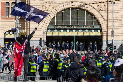 Manifestantes anti cuarentena marchan en un mitin frente a la estación de Flinders Street en Melbourne bloqueando el tráfico y los tranvías