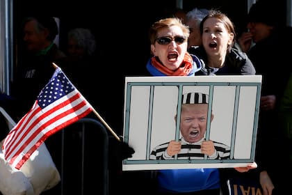Manifestantes anti-Trump protestan frente a la oficina del fiscal de distrito de Manhattan en la ciudad de Nueva York el 21 de marzo de 2023