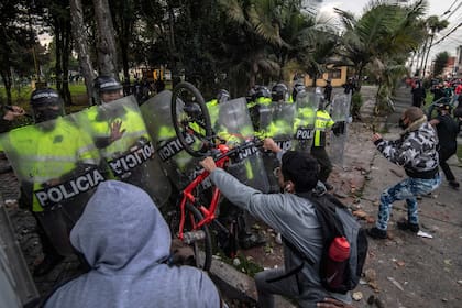 Manifestantes chocan con la policía antidisturbios durante una protesta contra la muerte de un abogado bajo custodia policial, en Bogotá el 9 de septiembre de 2020