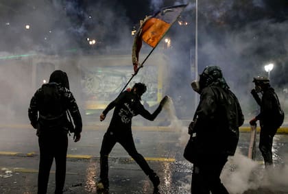 Manifestantes chocan con la policía durante una protesta para conmemorar el segundo aniversario de meses de levantamiento civil contra la desigualdad social, en Santiago (Photo by Javier TORRES / AFP)